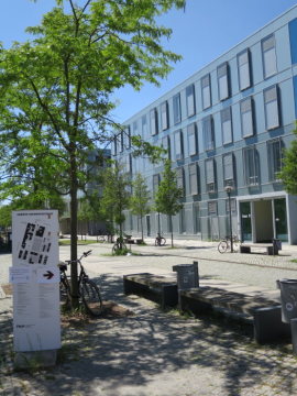Schrägansicht von Haus D des Fachbereichs Design mit Lageplanhinweisschild auf dem Campus der Fachhochschule Potsdam.